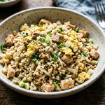 A rice-style dish made with finely chopped cauliflower, diced chicken, egg, and green onion, combined into a loose mixture with a light golden color and distinct texture.