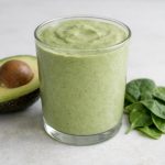 A thick, creamy low-carb smoothie made with avocado and spinach, blended into a smooth and filling drink.